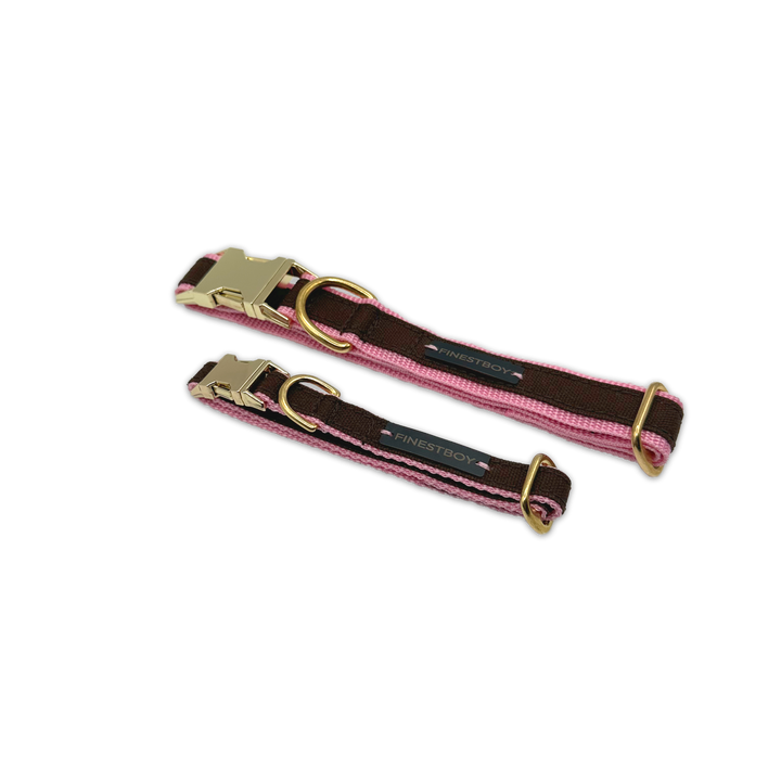 Zwei FINESTBOY-Halsbänder, 15mm und 25mm, rosafarbenes Gurtband mit dunkelbraunem Canvas-Streifen und Vollmessing-Applikationen und vermessingter Metallsteckschnalle, gelegt, diagonal drapiert