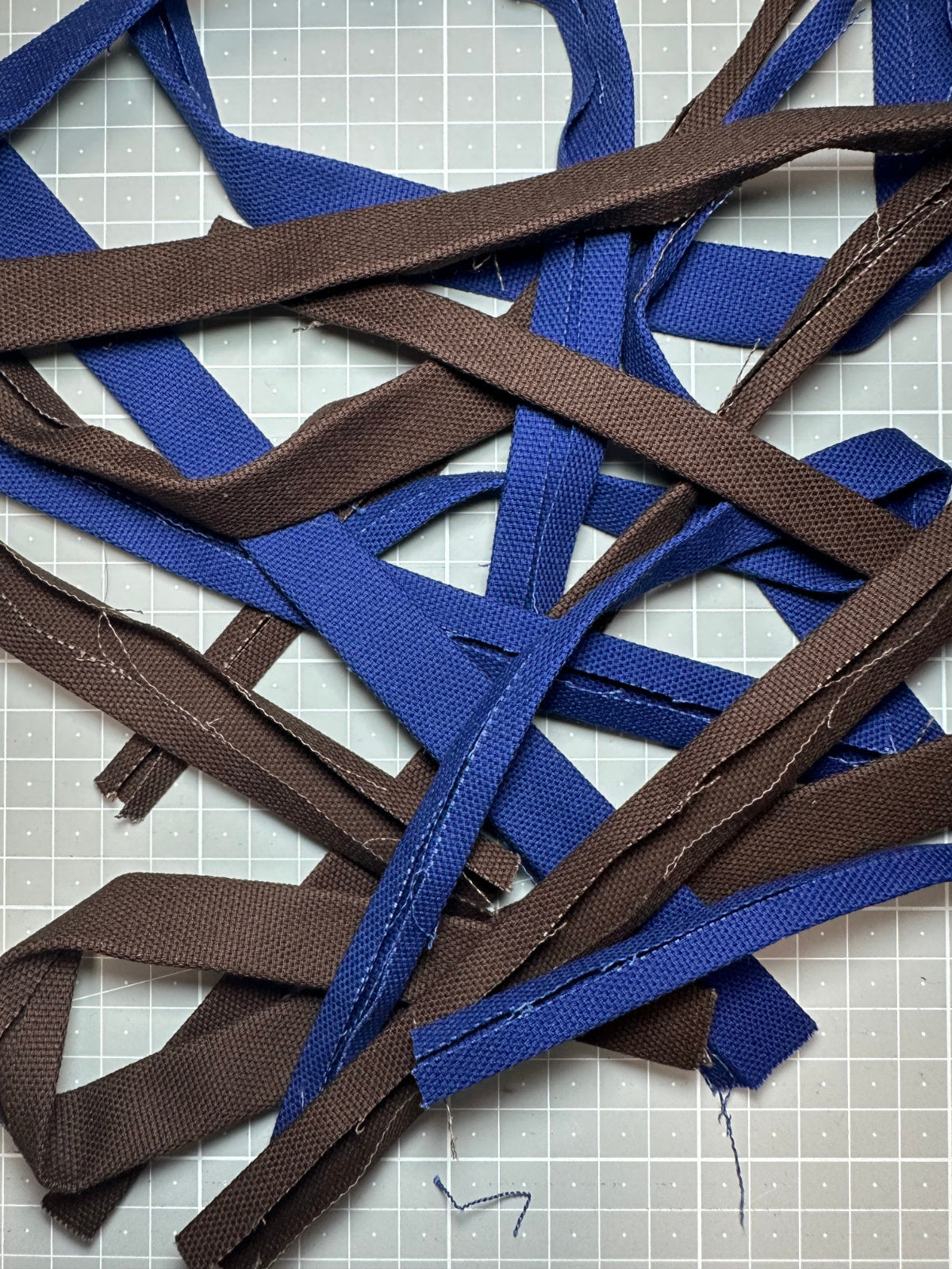 FINESTBOY Canvas-Streifen in Royalblau und Dunkelbraun — Rohmaterial für handgefertigte Hundeleinen und Halsbänder, liegend auf Schneidematte im Atelier Hamburg.