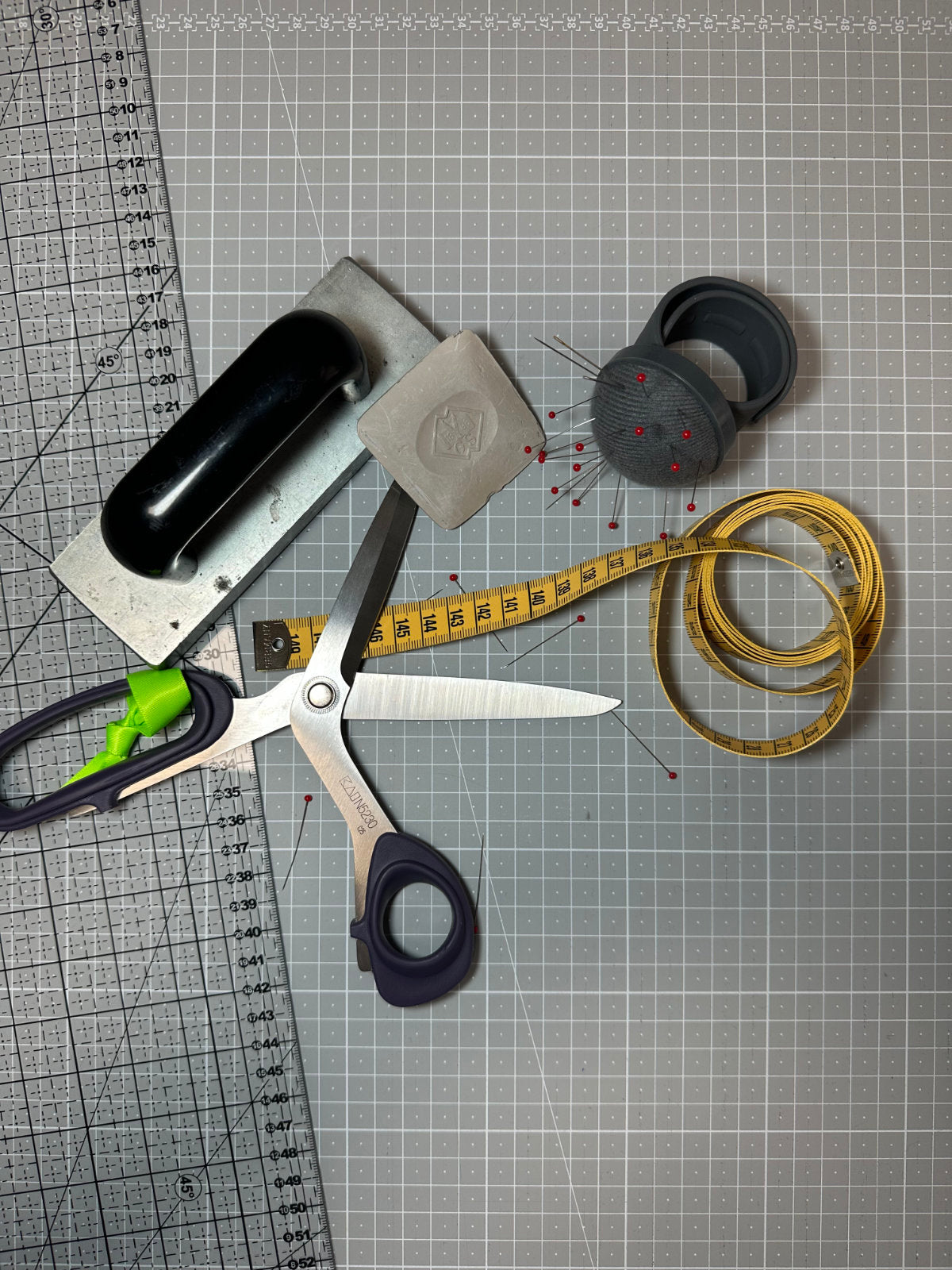 FINESTBOY Zuschnitt-Werkzeug für die handgefertigte Herstellung von Hundeleinen und Halsbändern — Schneiderschere, Maßband, Nadelkissen, Schneiderkreide, Gewichte und Lineal auf Schneidematte im Atelier Hamburg.